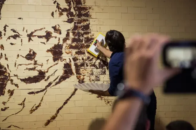 El público fotografía la creación del mural de Goya